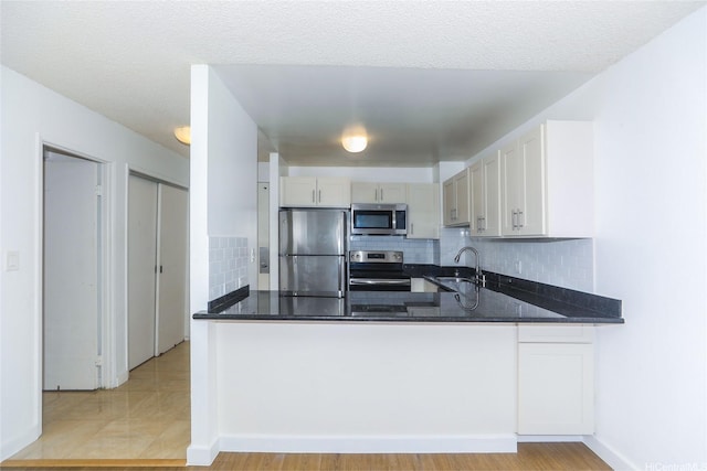 1255 Nuuanu Ave Unit E2804, Honolulu, HI 96817 - kitchen with appliances with stainless steel finishes, a peninsula, decorative backsplash, and dark stone counters