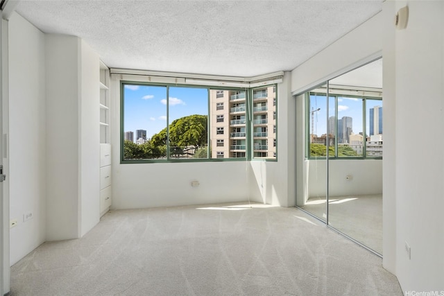 1314 Kalakaua Ave Unit 302, Honolulu, HI 96826 - carpeted empty room with healthy amount of natural light, a textured ceiling, and a city view