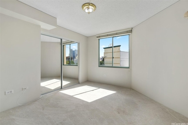 1314 Kalakaua Ave Unit 302, Honolulu, HI 96826 - unfurnished bedroom featuring carpet, a textured ceiling, and a closet
