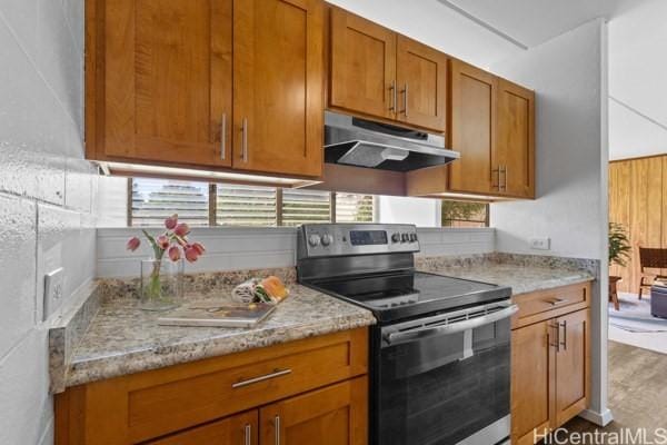 94-333 Hokuahiahi St Unit 103, Mililani, HI 96789 - kitchen with electric range, under cabinet range hood, brown cabinetry, and light stone counters