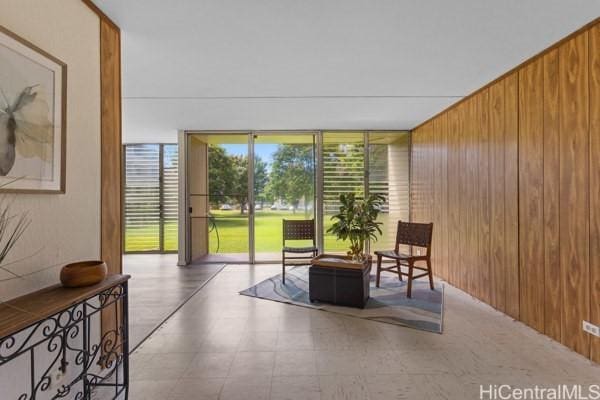 94-333 Hokuahiahi St Unit 103, Mililani, HI 96789 - sitting room featuring wood walls, floor to ceiling windows, and tile patterned floors