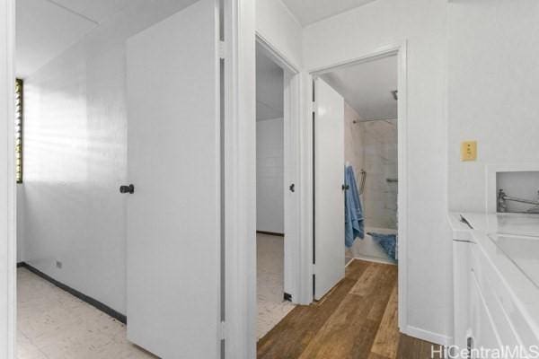 94-333 Hokuahiahi St Unit 103, Mililani, HI 96789 - corridor with light wood-type flooring and separate washer and dryer