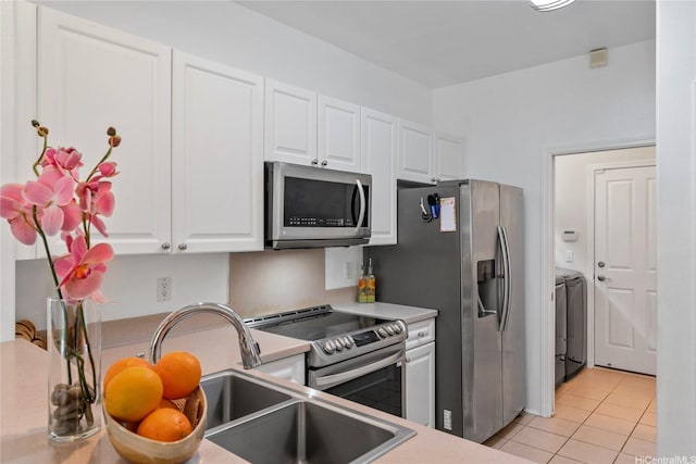 91-1200 Keaunui Dr Unit 110, Ewa Beach, HI 96706 - kitchen with stainless steel appliances, washer and dryer, white cabinetry, and light tile patterned flooring