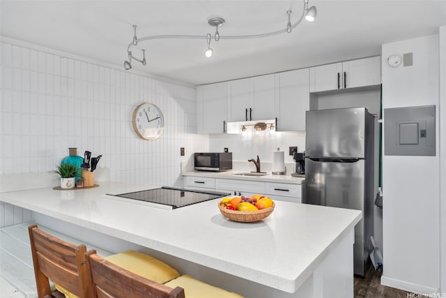 53-567 Kamehameha Hwy Unit 203, Hauula, HI 96717 - kitchen featuring stainless steel appliances, electric panel, a peninsula, light countertops, and white cabinets
