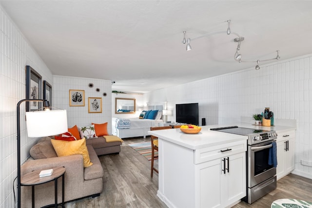 53-567 Kamehameha Hwy Unit 203, Hauula, HI 96717 - kitchen featuring stainless steel electric range oven, wood finished floors, white cabinetry, tile walls, and light countertops