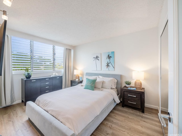 1545 Nehoa St Unit 101, Honolulu, HI 96822 - bedroom with a textured ceiling and light wood-style flooring
