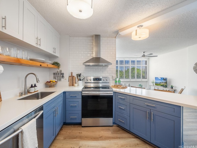 1545 Nehoa St Unit 101, Honolulu, HI 96822 - kitchen with wall chimney range hood, stainless steel appliances, a peninsula, white cabinets, and a textured ceiling