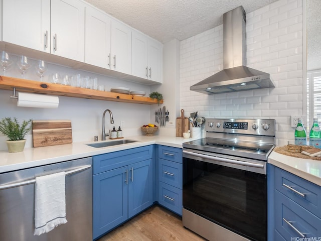 1545 Nehoa St Unit 101, Honolulu, HI 96822 - kitchen with appliances with stainless steel finishes, wall chimney range hood, blue cabinets, open shelves, and a textured ceiling