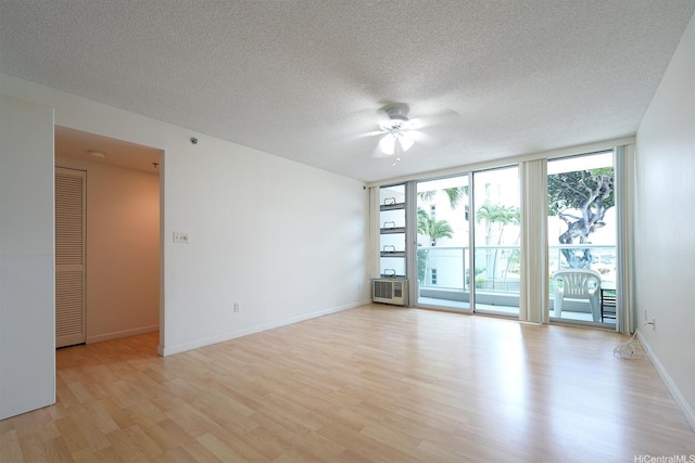 1448 Young St Unit 202, Honolulu, HI 96814 - empty room with light wood-type flooring, a ceiling fan, expansive windows, and a textured ceiling