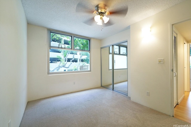 1448 Young St Unit 202, Honolulu, HI 96814 - unfurnished bedroom with light carpet, a textured ceiling, a closet, and a ceiling fan