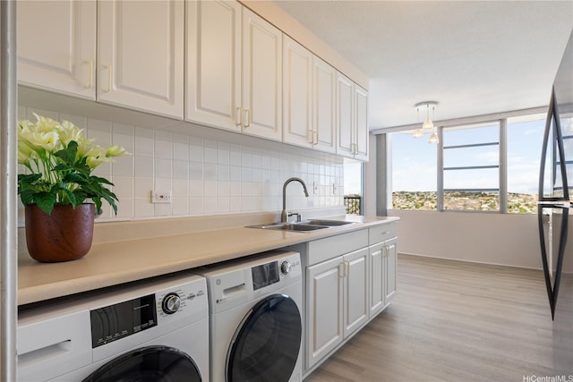 2825 S King St Unit 2403, Honolulu, HI 96826 - laundry room with washing machine and clothes dryer, light wood finished floors, and cabinet space