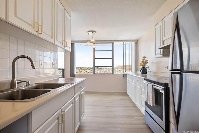 2825 S King St Unit 2403, Honolulu, HI 96826 - kitchen featuring appliances with stainless steel finishes, light wood finished floors, light countertops, white cabinetry, and backsplash