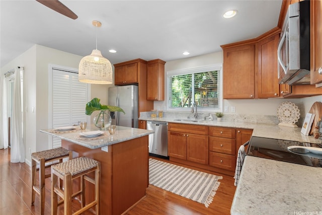 66-912 Kamakahala St Unit 2, Waialua, HI 96791 - kitchen with stainless steel appliances, a center island, brown cabinetry, recessed lighting, and light wood-style floors