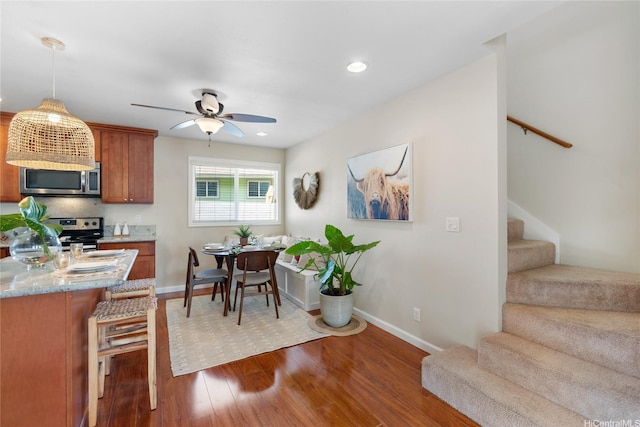 66-912 Kamakahala St Unit 2, Waialua, HI 96791 - kitchen with stainless steel appliances, ceiling fan, dark wood-style flooring, brown cabinetry, and recessed lighting