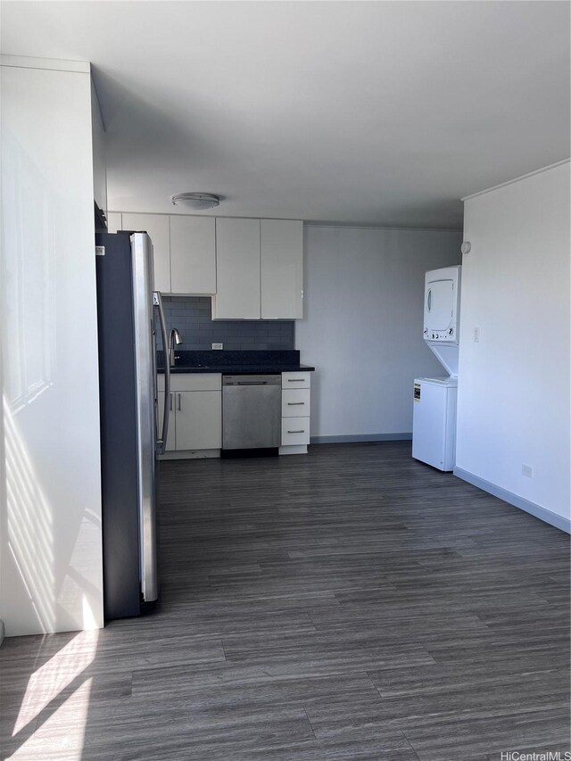 5210 Likini St Unit 901, Honolulu, HI 96818 - kitchen featuring stainless steel appliances, estacked washer and dryer, white cabinets, dark countertops, and dark wood finished floors