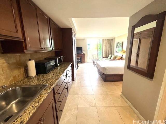 2045 Kalakaua Ave Unit 402, Honolulu, HI 96815 - kitchen featuring open floor plan, decorative backsplash, black microwave, dark stone counters, and dark brown cabinetry
