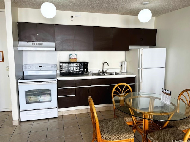 201 Ohua Ave Unit 2406, Honolulu, HI 96815 - kitchen with white appliances, under cabinet range hood, light countertops, dark tile patterned floors, and a textured ceiling