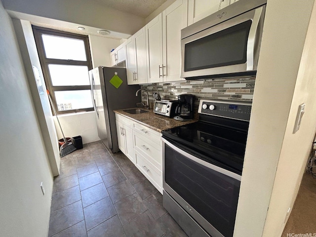 201 Ohua Ave Unit 2406, Honolulu, HI 96815 - kitchen featuring stainless steel appliances, white cabinetry, decorative backsplash, and dark stone counters