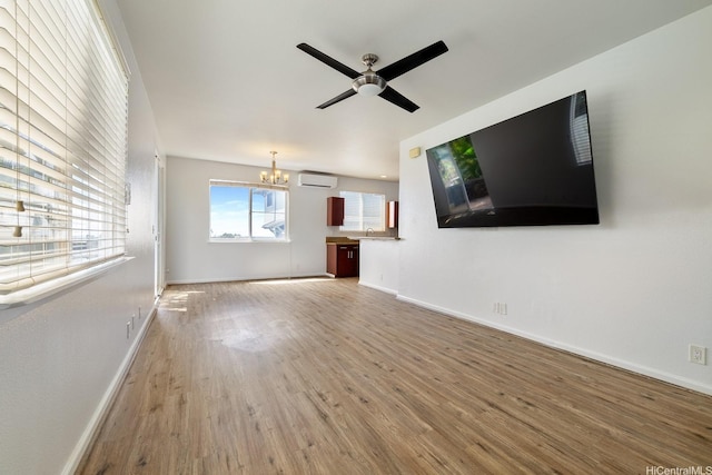 92-7049 Elele St Unit 54, Kapolei, HI 96707 - unfurnished living room featuring a wall unit AC, wood finished floors, ceiling fan, and a chandelier