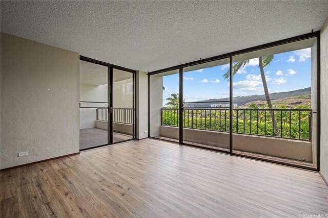 500 Lunalilo Home Rd Unit 24K, Honolulu, HI 96825 - spare room featuring a textured wall, wood finished floors, and a textured ceiling