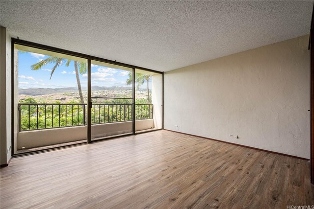 500 Lunalilo Home Rd Unit 24K, Honolulu, HI 96825 - empty room featuring wood finished floors, a textured ceiling, floor to ceiling windows, and a textured wall