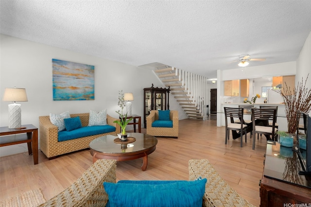 444 Lunalilo Home Rd Unit 602, Honolulu, HI 96825 - living room featuring stairs, light wood-style flooring, a textured ceiling, and a ceiling fan