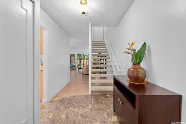 444 Lunalilo Home Rd Unit 602, Honolulu, HI 96825 - foyer entrance featuring light stone finish floors, stairway, and a textured ceiling