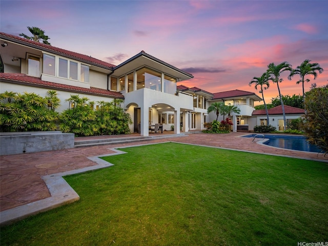 3124 Noela Dr, Honolulu, HI 96815 - rear view of house with a balcony, a patio, a lawn, an outdoor pool, and stucco siding