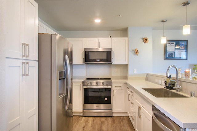 91-3525 Kauluakoko St Unit 2103, Ewa Beach, HI 96706 - kitchen with appliances with stainless steel finishes, light wood-type flooring, white cabinets, a peninsula, and light countertops
