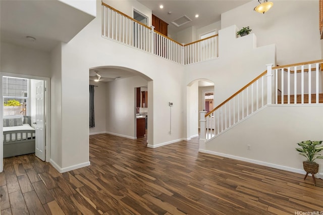 91-1023 Kaiee St, Ewa Beach, HI 96706 - foyer featuring dark wood-type flooring, arched walkways, a towering ceiling, and stairs