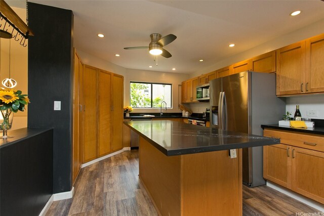 46-359 Haiku Rd Unit C10, Kaneohe, HI 96744 - kitchen featuring appliances with stainless steel finishes, dark wood-style floors, dark countertops, a ceiling fan, and a kitchen island