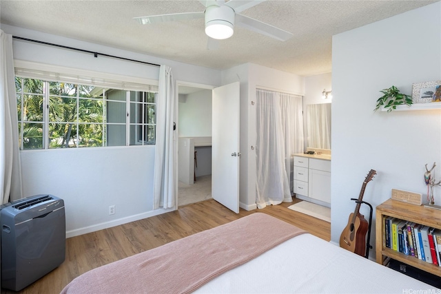 239 Mananai Pl Unit 54H, Honolulu, HI 96818 - bedroom featuring wood finished floors, a textured ceiling, ensuite bath, and a ceiling fan