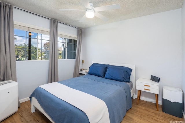 239 Mananai Pl Unit 54H, Honolulu, HI 96818 - bedroom with wood finished floors, a textured ceiling, and ceiling fan