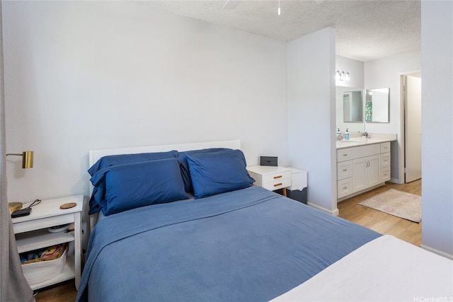 239 Mananai Pl Unit 54H, Honolulu, HI 96818 - bedroom with light wood finished floors, a textured ceiling, and ensuite bath