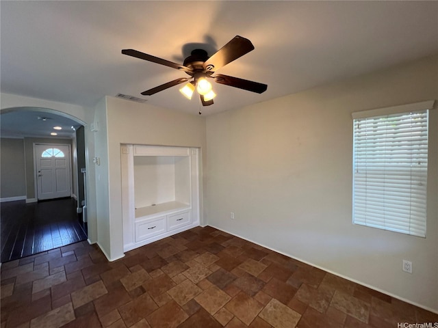 91-1035 Kaiko St, Ewa Beach, HI 96706 - empty room with arched walkways, a ceiling fan, and stone tile flooring