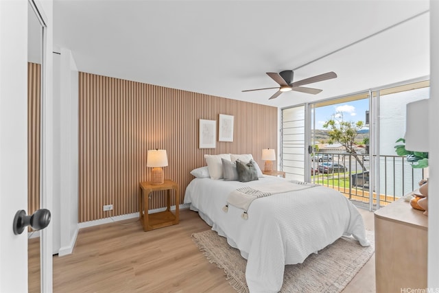 5055 Likini St Unit D226, Honolulu, HI 96818 - bedroom with access to outside, light wood finished floors, a ceiling fan, and an accent wall