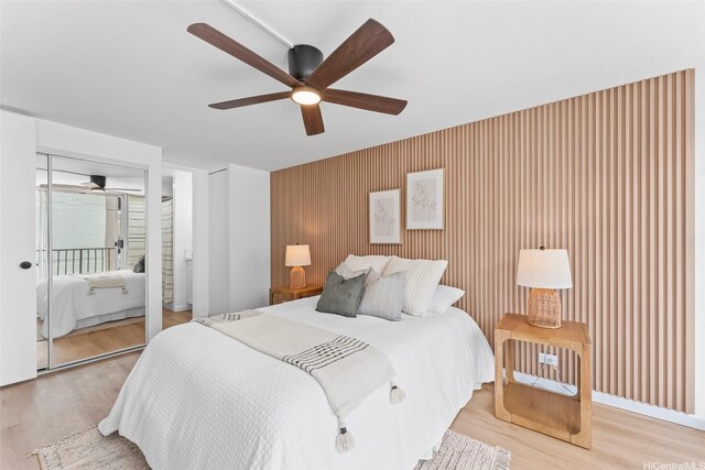 5055 Likini St Unit D226, Honolulu, HI 96818 - bedroom featuring an accent wall, light wood finished floors, and ceiling fan