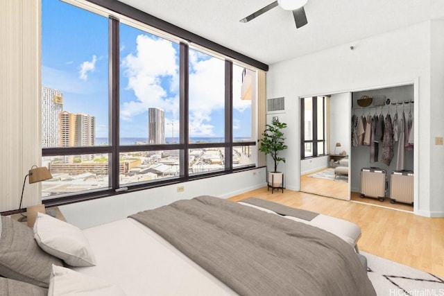 725 Kapiolani Blvd Unit 1802, Honolulu, HI 96813 - bedroom with radiator heating unit, wood finished floors, a closet, and a view of city