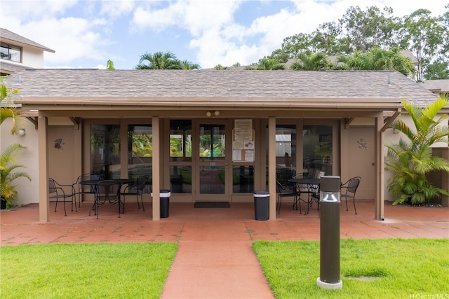 95-142 Kuahelani Ave Unit 251, Mililani, HI 96789 - view of exterior entry with a patio, roof with shingles, stucco siding, and a yard