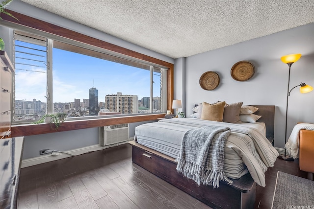 747 Amana St Unit 2206, Honolulu, HI 96814 - bedroom featuring a skyline view, multiple windows, wood finished floors, a textured ceiling, and a wall unit AC