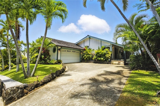 866 Kaahue St, Honolulu, HI 96825 - view of front of property featuring board and batten siding, an attached garage, driveway, and a front lawn