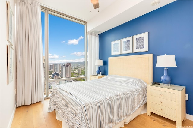 1001 Queen St Unit 3907, Honolulu, HI 96814 - bedroom featuring wood finished floors, floor to ceiling windows, and a ceiling fan