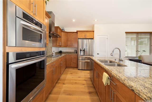 91-1144 Kaikohola St Unit D71, Ewa Beach, HI 96706 - kitchen with stainless steel appliances, wall chimney exhaust hood, brown cabinetry, light wood-style flooring, and light stone countertops