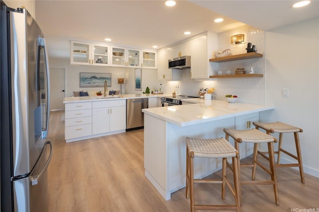 539 Keolu Dr Unit C, Kailua, HI 96734 - kitchen with stainless steel appliances, a peninsula, white cabinets, light wood-style floors, and recessed lighting