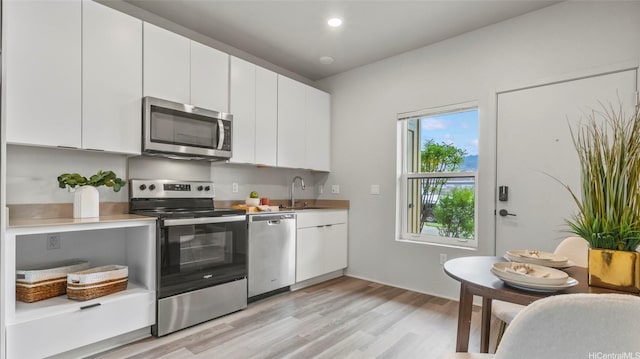 91-3617 Kamolehonua St Unit 208, Ewa Beach, HI 96706 - kitchen with stainless steel appliances, light wood-style floors, white cabinets, light countertops, and recessed lighting