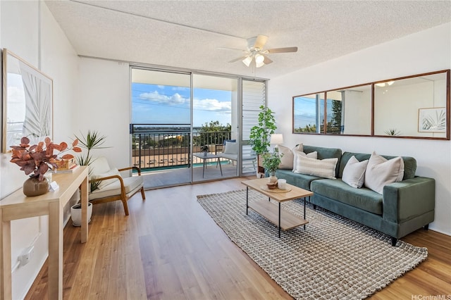 98-099 Uao Pl Unit 506, Aiea, HI 96701 - living room featuring a ceiling fan, a wall of windows, a textured ceiling, and wood finished floors