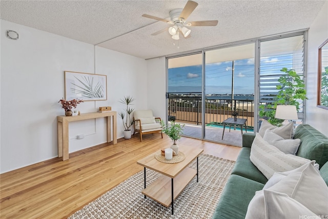 98-099 Uao Pl Unit 506, Aiea, HI 96701 - living room with a ceiling fan, a textured ceiling, wood finished floors, and a wall of windows