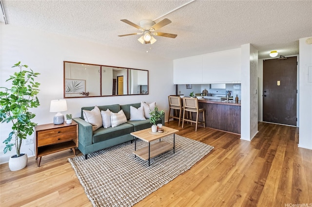 98-099 Uao Pl Unit 506, Aiea, HI 96701 - living room with light wood-type flooring, a ceiling fan, and a textured ceiling
