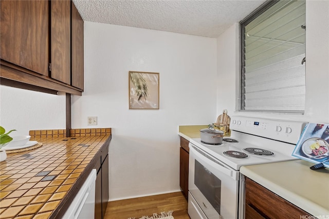 98-099 Uao Pl Unit 506, Aiea, HI 96701 - kitchen with white appliances, tile counters, a textured ceiling, and wood finished floors
