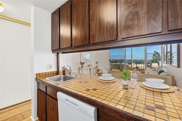 98-099 Uao Pl Unit 506, Aiea, HI 96701 - kitchen with dishwasher, tile counters, light wood-style floors, a textured ceiling, and dark brown cabinets